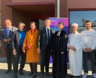 Bild von der Eröffnung des Quartiersbüros: Bürgermeister Christian Vogel, Sozialreferentin Elisabeth Ries, Stadträtin Christine Kayser, Oberbürgermeister Markus König, Pfarrerin Julia Popp (Lichtenreuth.Gemeinsam), Mehmet Çelik (Imam der DITIB – Türkisch Islamische Gemeinde zu Erlangen e.V.) und Bewohner:innen von Lichtenreuth.